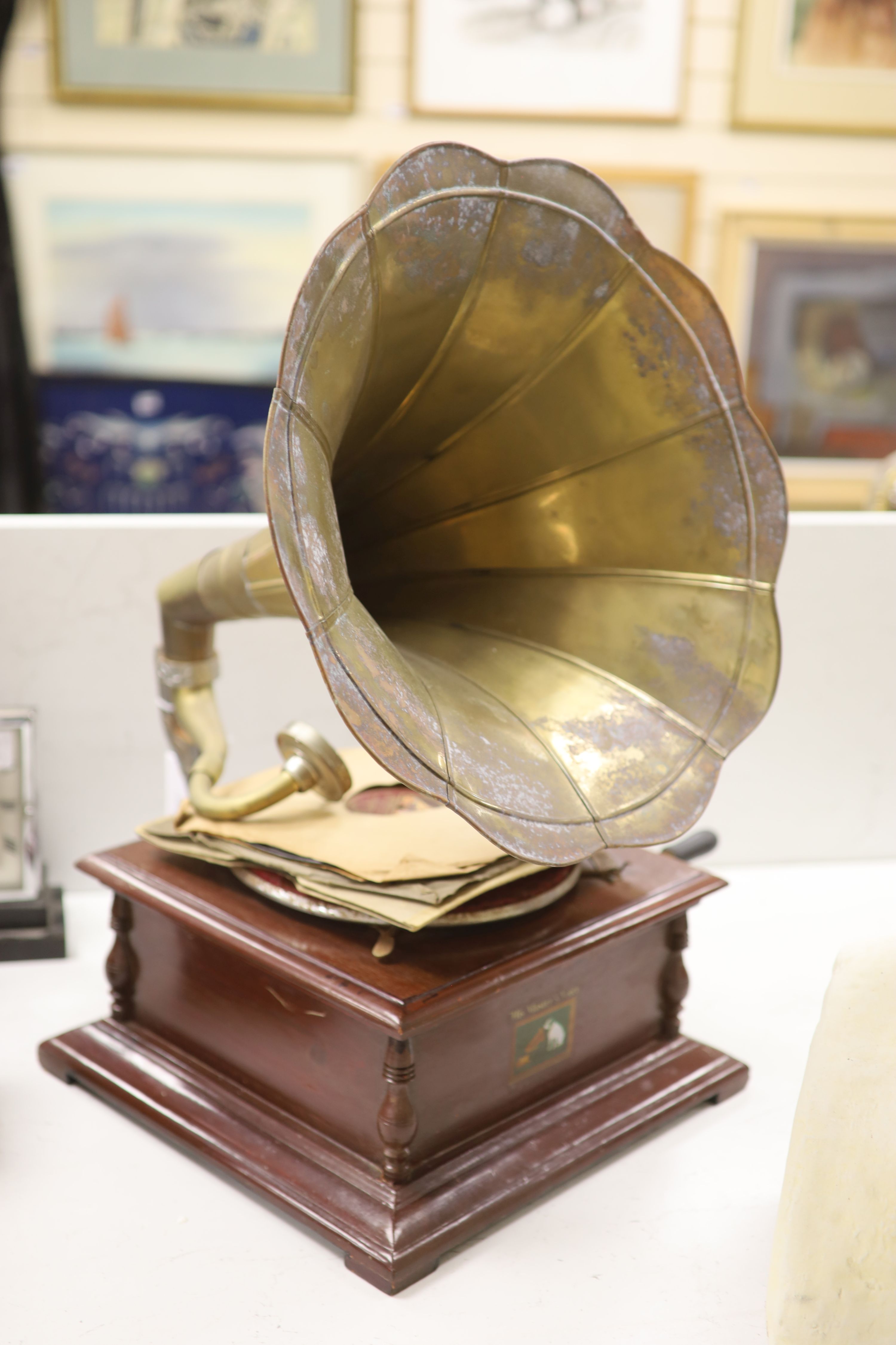 An HMV wind up gramophone with brass horn and three discs